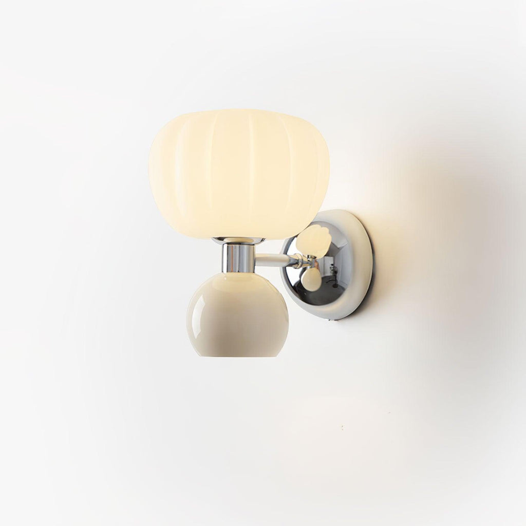 Close view of this Clérachic chrome wall light with a cream ball and ribbed glass shade, glowing against a pale backdrop.