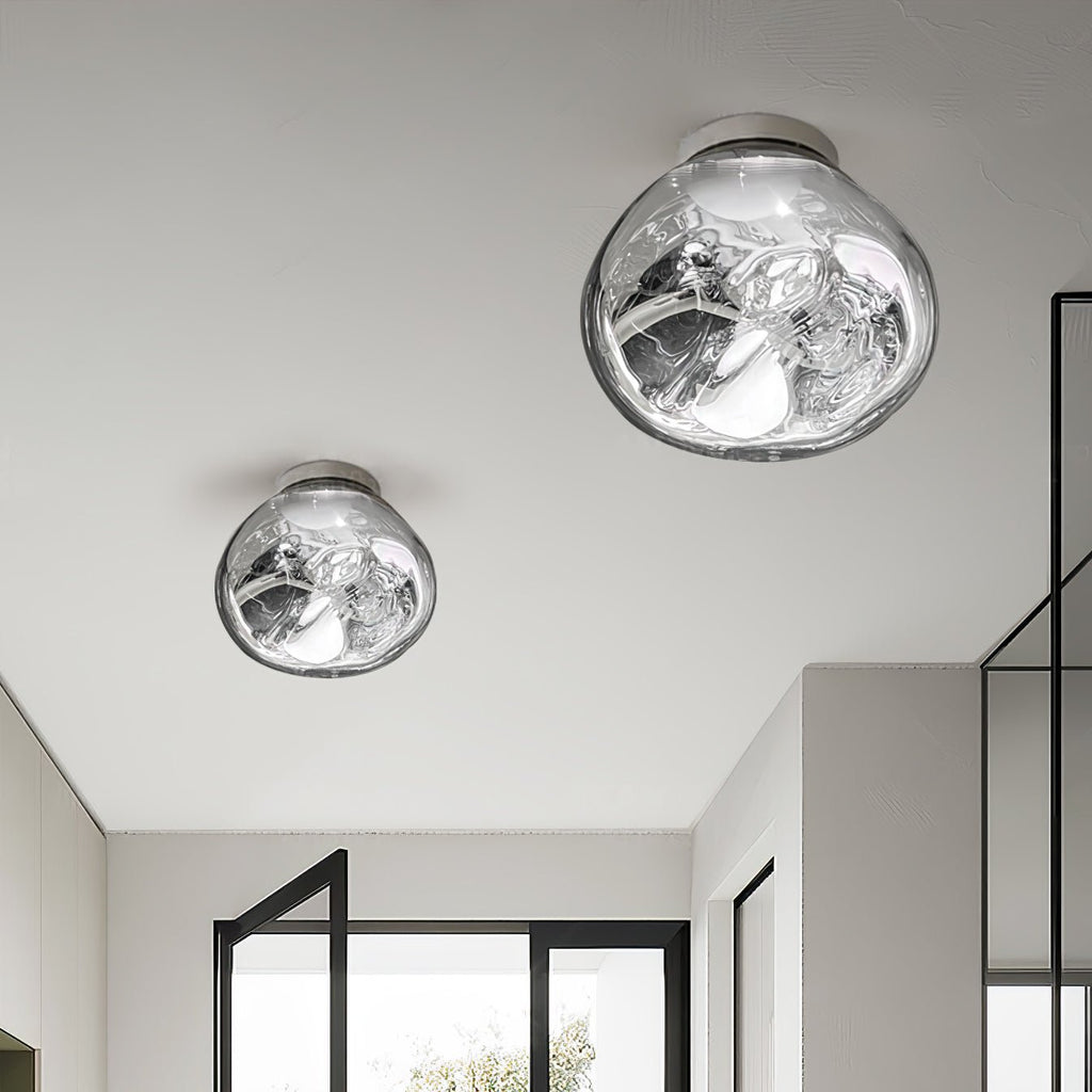 Two Clérachic ceiling-mounted lights in a mirror-silver finish, in different sizes, above a hallway with black-framed glazing.