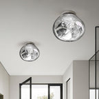 Two Clérachic ceiling-mounted lights in a mirror-silver finish, in different sizes, above a hallway with black-framed glazing.