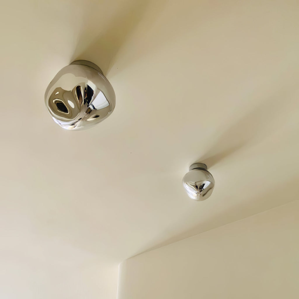 Two Clérachic ceiling lights in silver, one large and one small, on a cream-coloured ceiling.