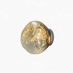 A Clérachic wall light with a melted-glass shade in a smoky champagne tone, on a plain white backdrop.