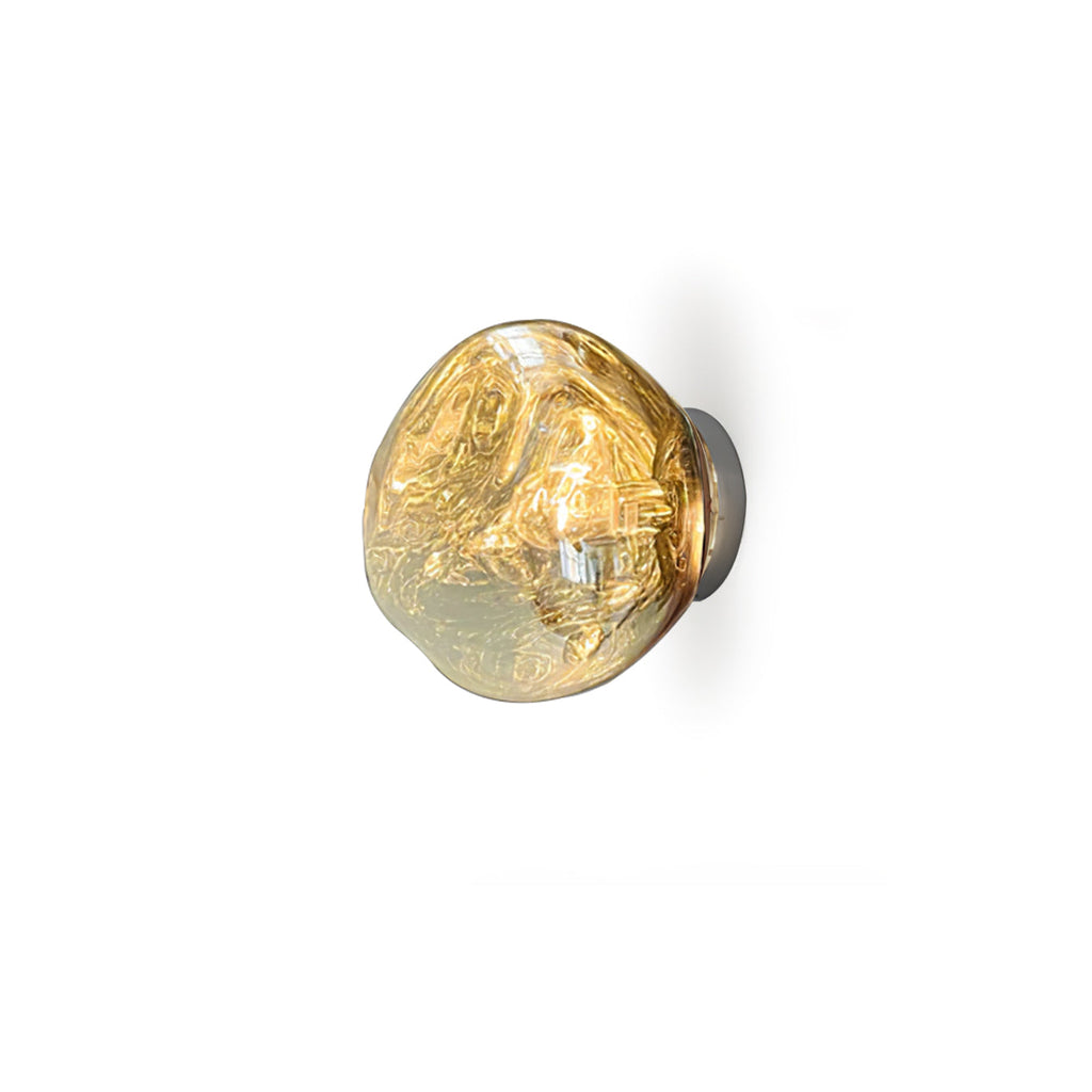 A Clérachic wall light in a gold finish with a bright filament bulb, on a white background.
