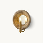 A Clérachic wall light with a round, weathered wood surround, a mirrored centre and a gold candle-style fitting, on a white backdrop.