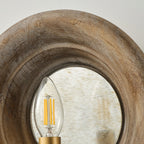 Close view of the wood surround, the aged mirror disc and a filament candle bulb on this Clérachic wall light.