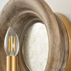 Close view of the grained wood rim, the mirror and a filament candle bulb on this Clérachic wall light.
