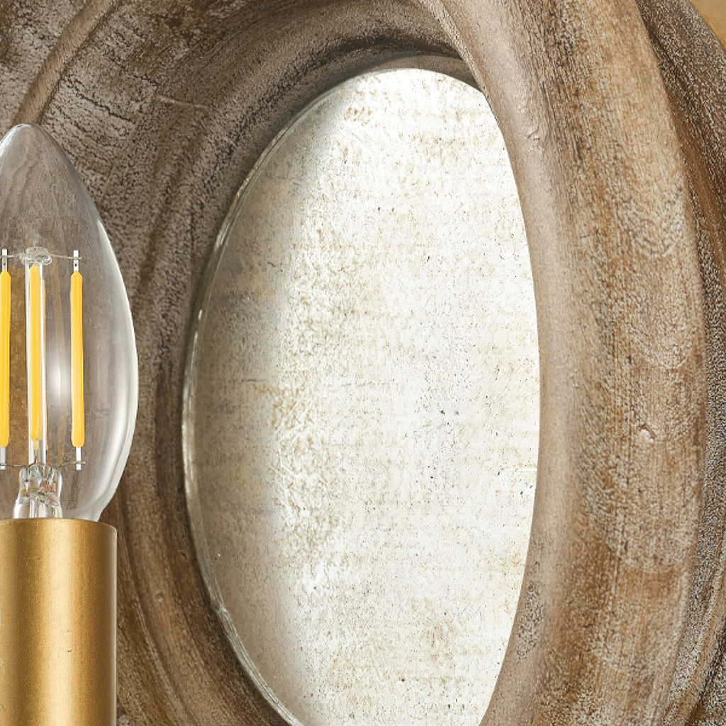 Close view of the oval mirror inside the wood surround of this Clérachic wall light, with a candle bulb at the edge.