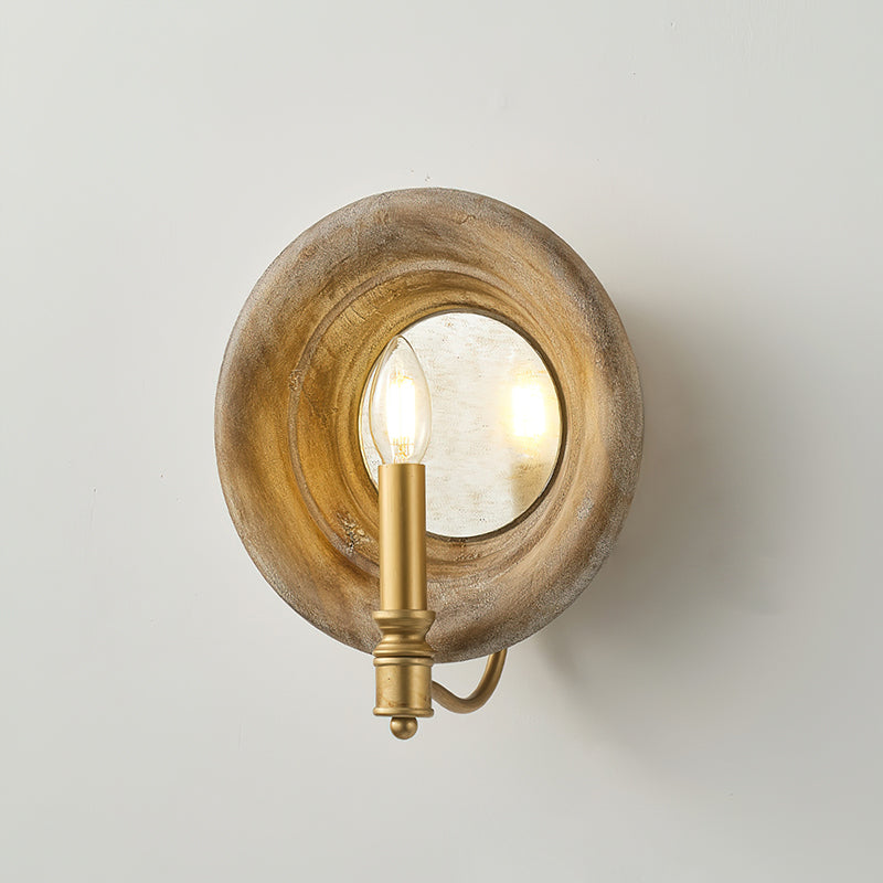 A smaller view of the Clérachic round wood wall light with its gold candle fitting and curved arm, on a pale grey wall.