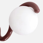 Close view of the Clérachic Citheis globe from underneath, burgundy arm sweeping past.