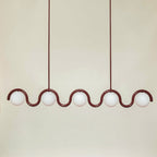The Clérachic Citheis five-head chandelier in burgundy, wave rail spanning a cream wall.