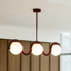 Clérachic Citheis three-head chandelier angled, burgundy rail lit against oak panels.