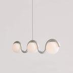 Clérachic Citheis three-head chandelier in silver, wave rail dipping between the globes.