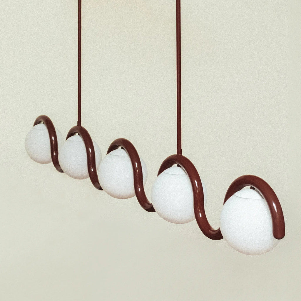 The Clérachic Citheis five-head chandelier angled on cream, globes stepping along the wave.