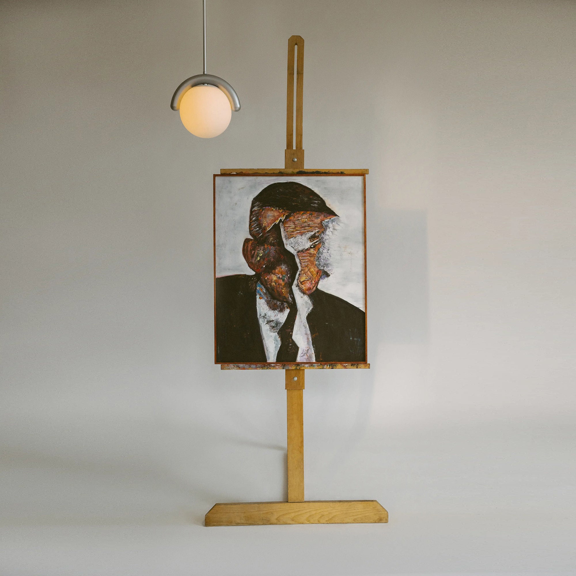 The Clérachic Citheis single pendant hung above a framed portrait propped on an easel.