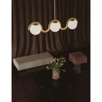 Clérachic Citheis three-head chandelier over a dark table set with tulips and a bench.