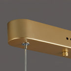 Close view of the gold canopy end on this Clérachic pendant light, with a clear wire gripper and a small adjusting knob.