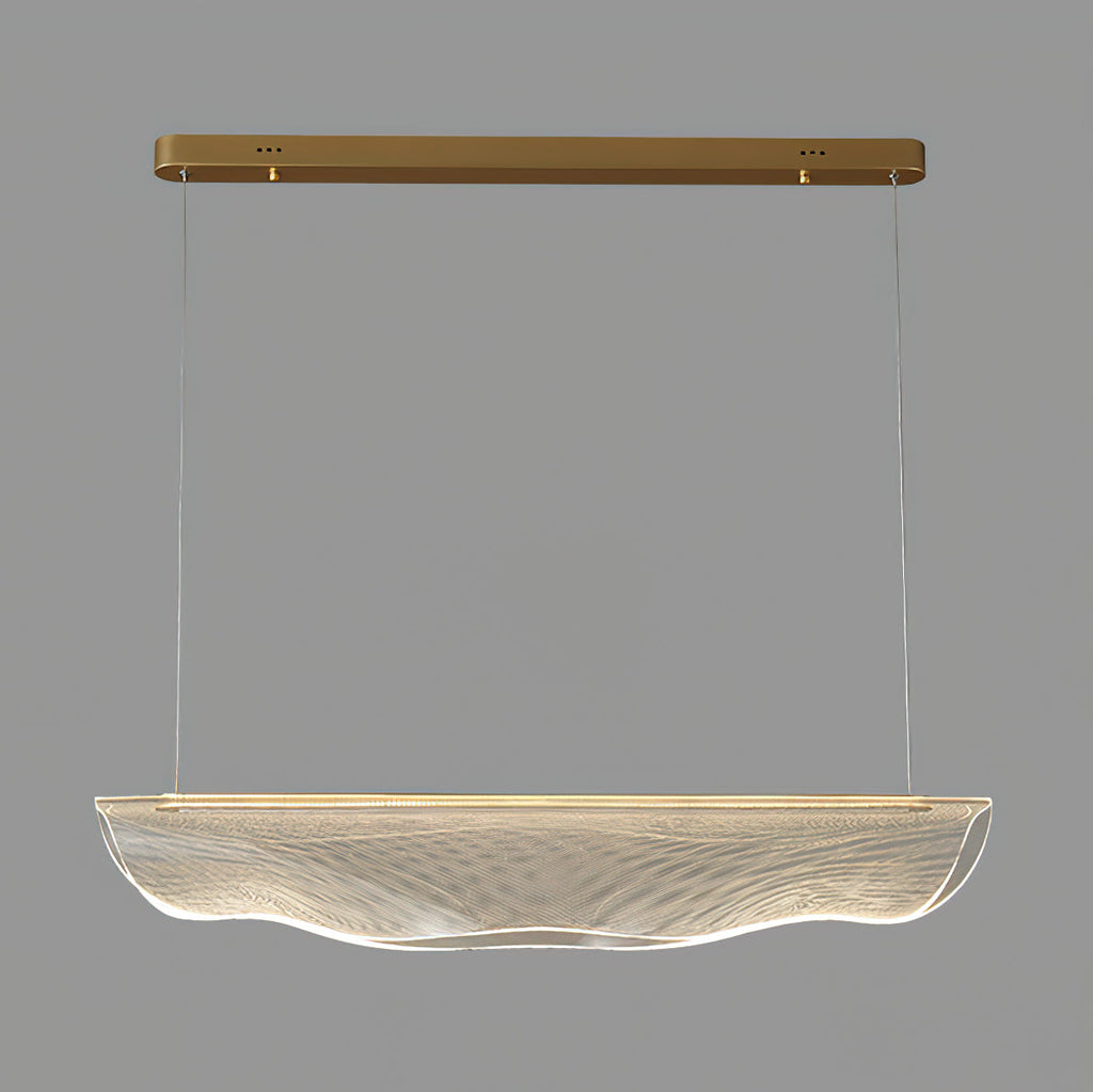Close view of the unlit clear shade on this Clérachic pendant light, wavy at the lower edge, with gold canopy and wires above.