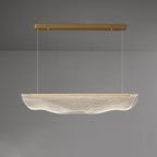 Same lit Clérachic pendant light on grey, viewed straight on, with the shade and its wavy lower edge softly glowing.