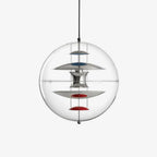A Clérachic sphere pendant on a plain white backdrop, showing chrome discs with blue and red dishes inside the clear acrylic sphere.