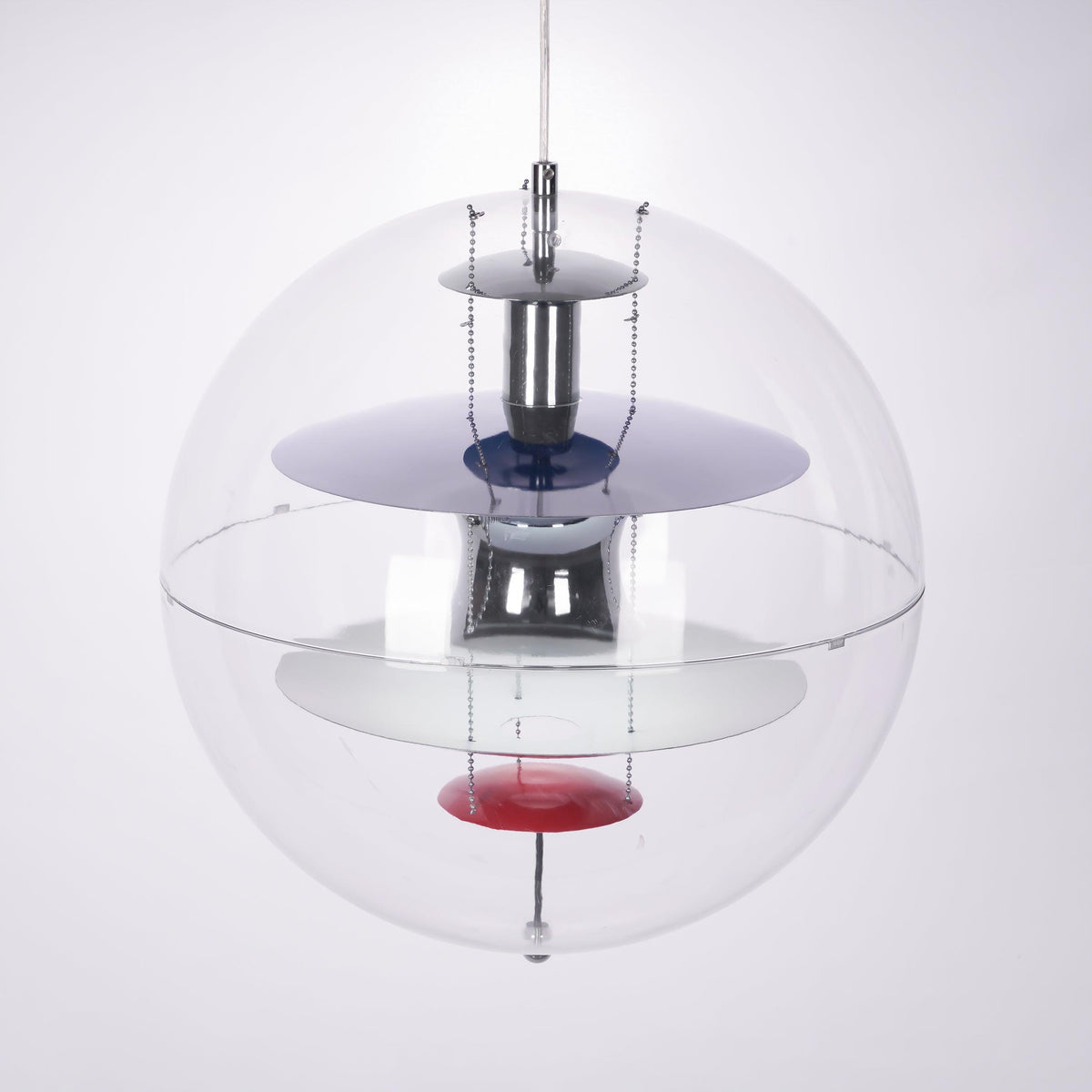Close view of the layered chrome and white discs, blue ring and red dish inside this Clérachic acrylic sphere pendant.