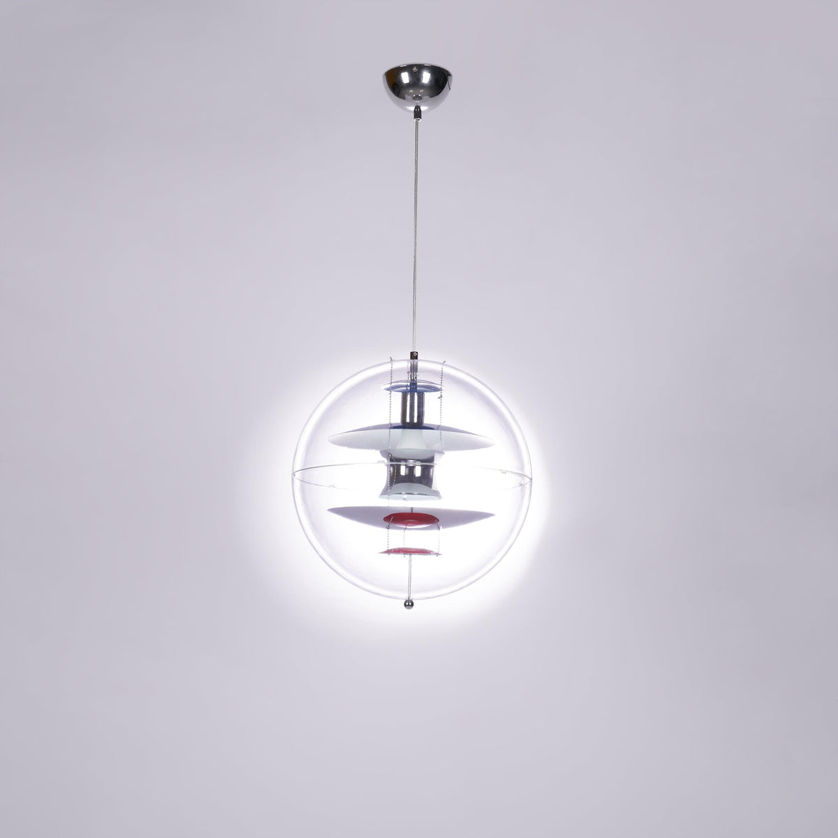 Seen from below with a bright halo of light around it, this Clérachic sphere pendant hangs from a chrome ceiling canopy.