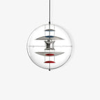 A Clérachic sphere pendant on a white backdrop, showing chrome discs and red dishes on chains inside the clear acrylic sphere.
