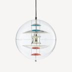 A Clérachic sphere pendant on an off-white backdrop, with chrome discs, turquoise upper dishes and coral-red lower dishes inside the clear sphere.