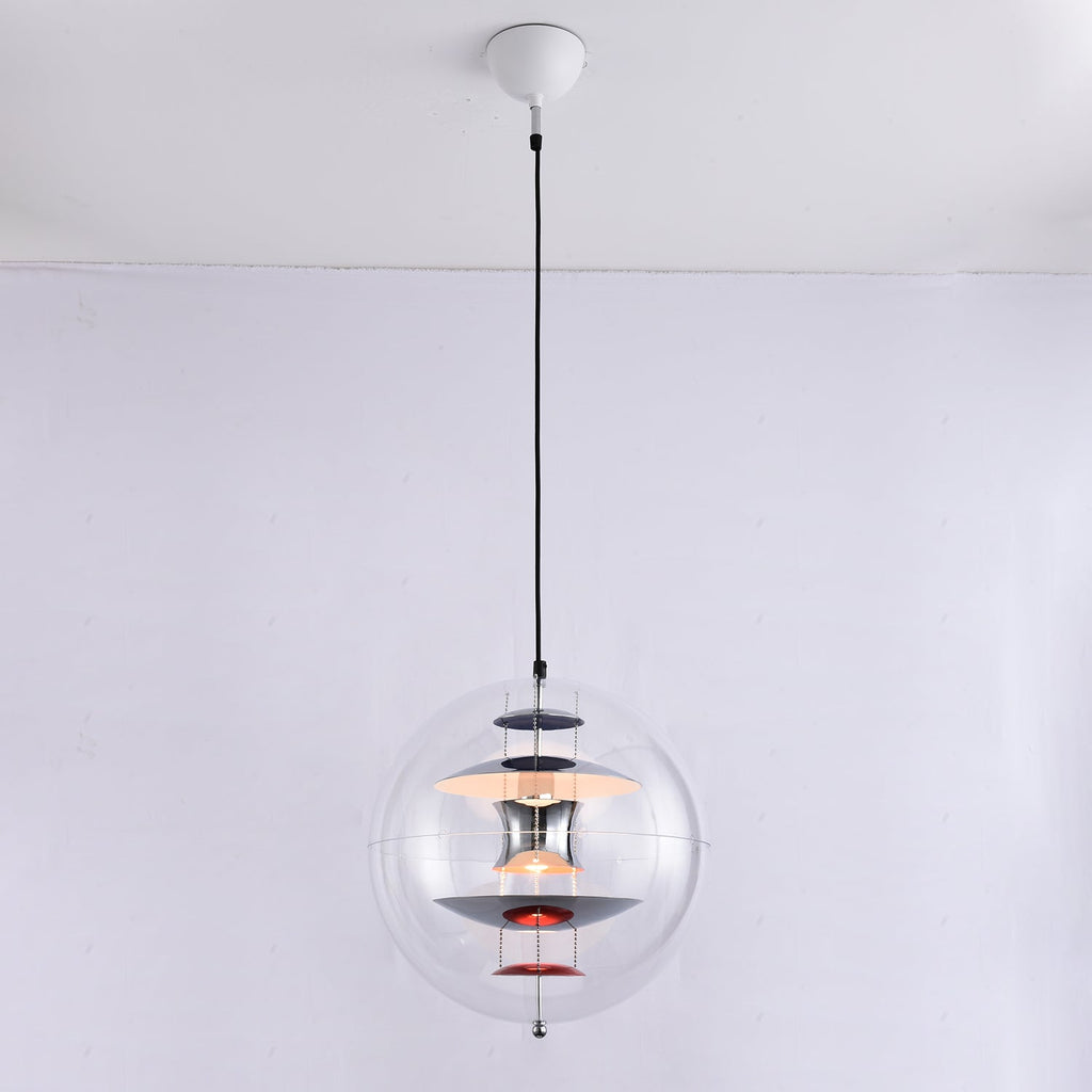 The same chrome-and-red Clérachic sphere pendant, now switched on, with a warm glow lighting the discs inside the acrylic sphere.