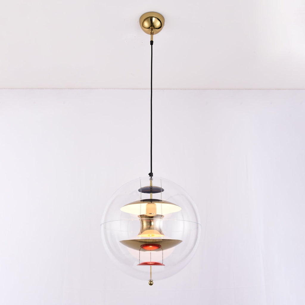 A Clérachic sphere pendant with a gold ceiling canopy and black cord, lit warmly, with brass discs and red dishes inside.