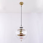 Seen close to the gold canopy, this Clérachic sphere pendant glows with brass-toned discs, a white upper disc and red dishes.