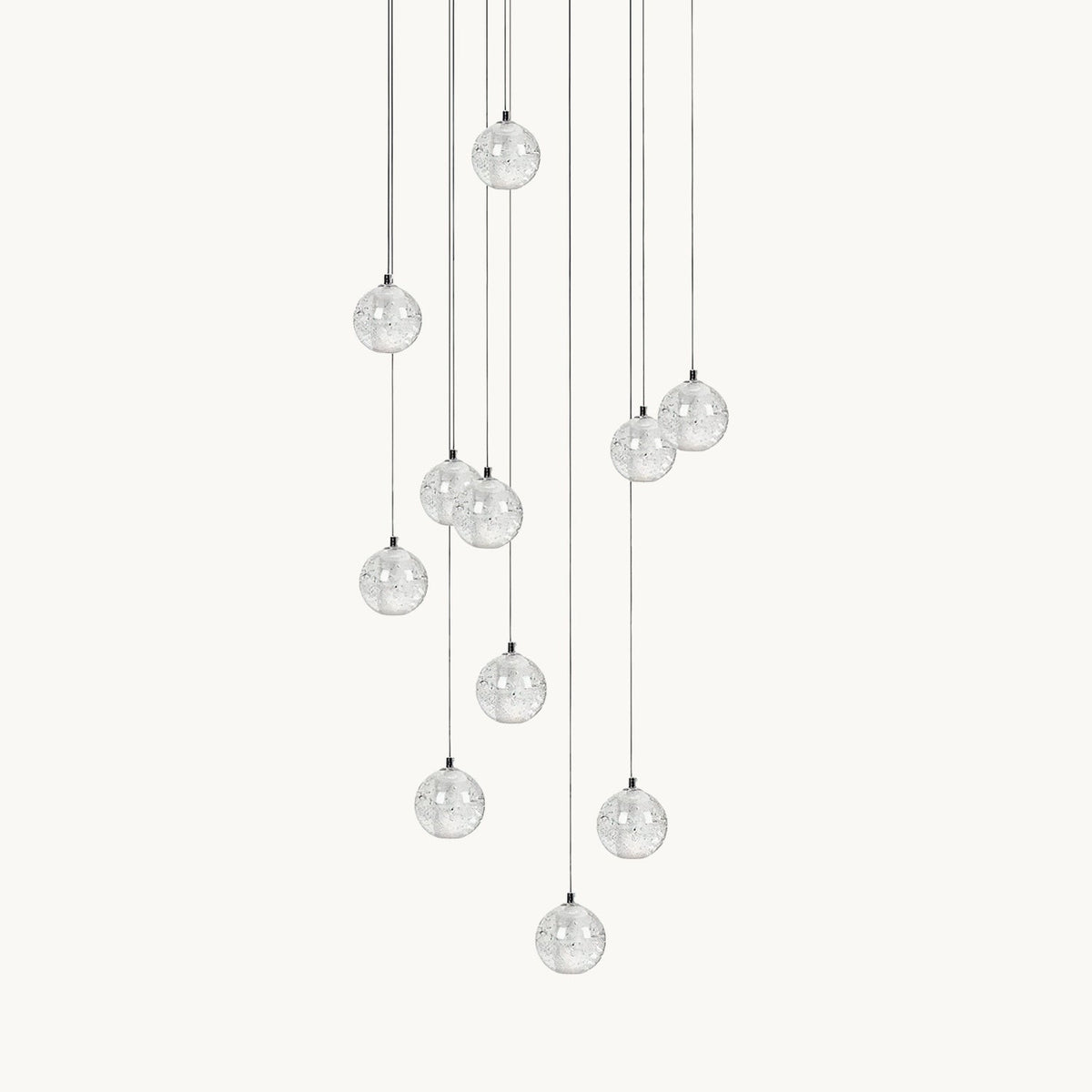 A Clérachic pendant light on a plain white backdrop, a loose cluster of clear glass spheres hung at different heights on thin cords.