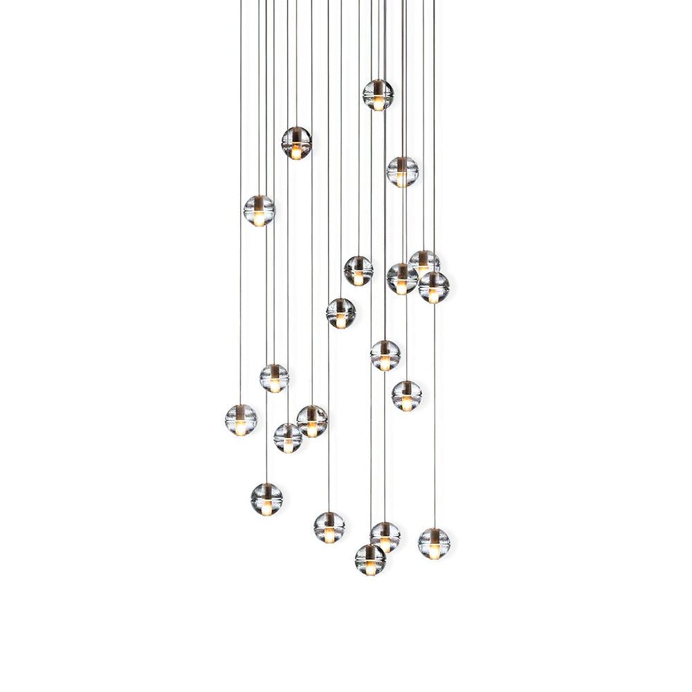 A cluster of clear glass spheres from this Clérachic pendant light on a white backdrop, each with a dark metal cap on a thin cord.