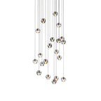 A cluster of clear glass spheres from this Clérachic pendant light on a white backdrop, each with a dark metal cap on a thin cord.