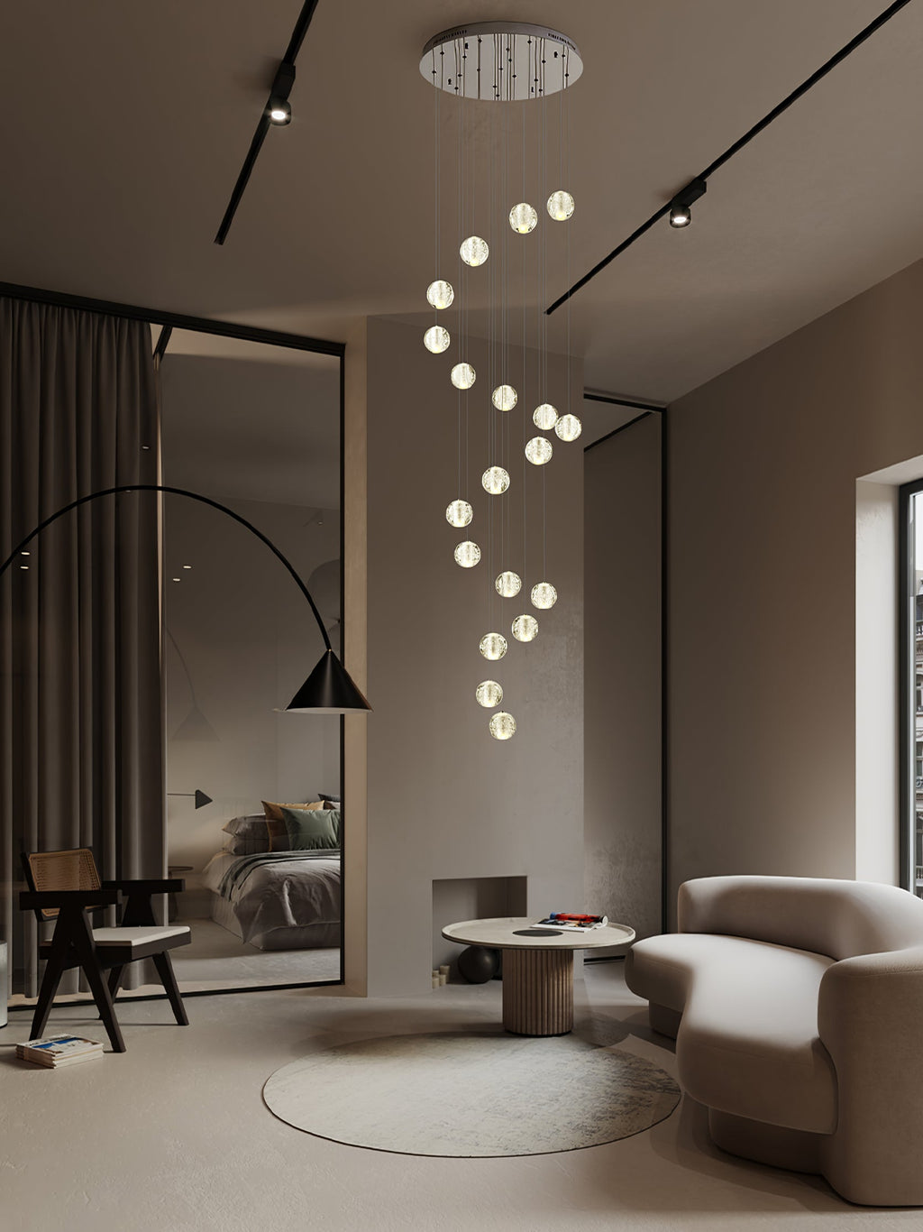 A spiral of lit glass spheres from this Clérachic pendant light drops from a round ceiling plate into a taupe living room.