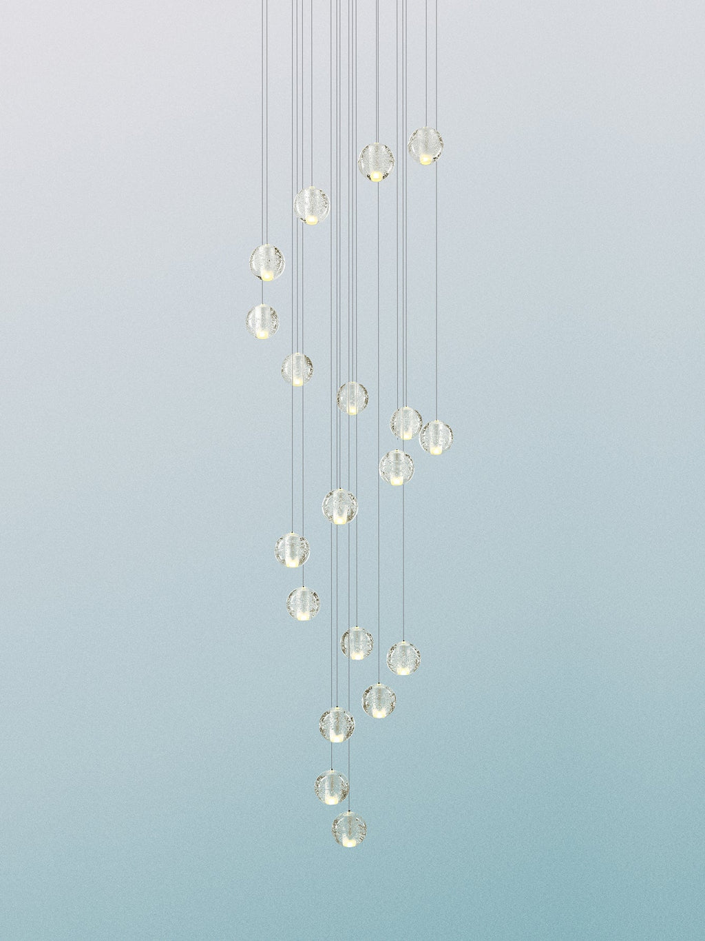 A column of pale glass spheres from this Clérachic pendant light against a soft blue-green gradient, hung on fine cords.