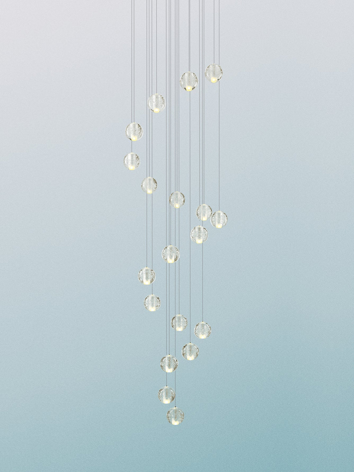 A column of pale glass spheres from this Clérachic pendant light against a soft blue-green gradient, hung on fine cords.