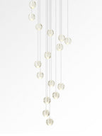 This Clérachic pendant light on white, a tall trail of softly lit clear spheres hung at staggered heights.