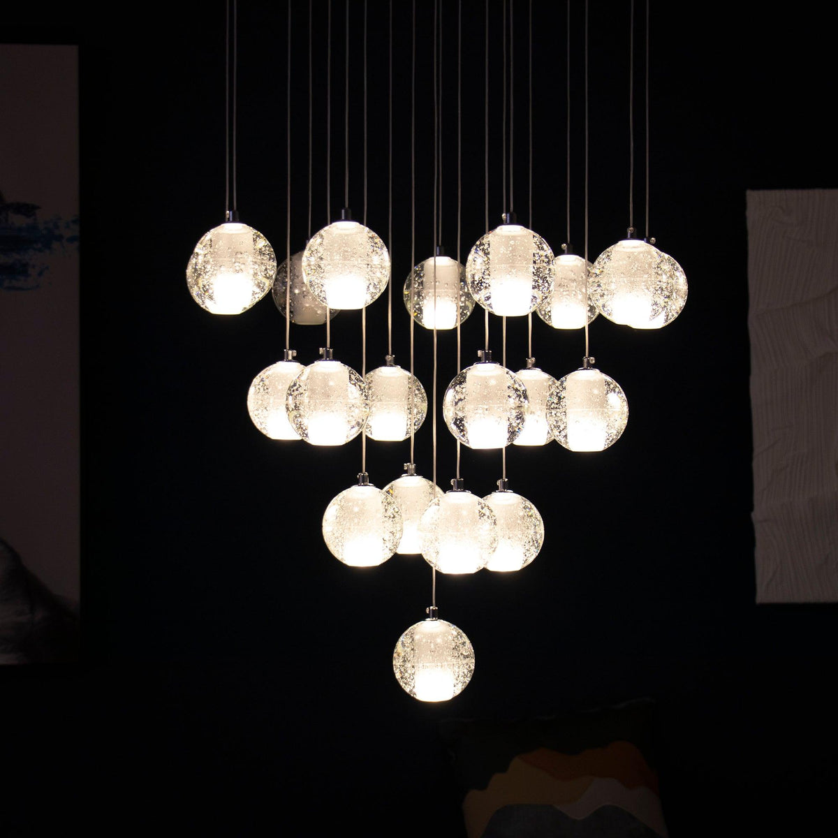 Against a black background, this Clérachic pendant light shows about twenty warmly lit spheres hung in a dense, rounded cluster.