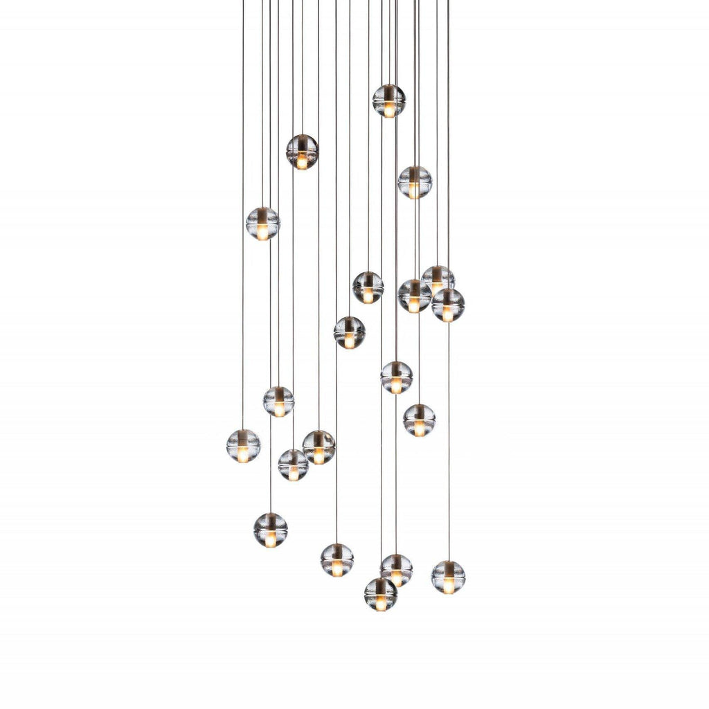A tall spread of small clear spheres from this Clérachic pendant light on a white backdrop, hung at many different heights.