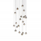 A tall spread of small clear spheres from this Clérachic pendant light on a white backdrop, hung at many different heights.