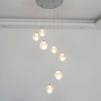 This Clérachic pendant light hangs nine spheres from a round chrome ceiling plate, with a recessed ceiling edge behind.