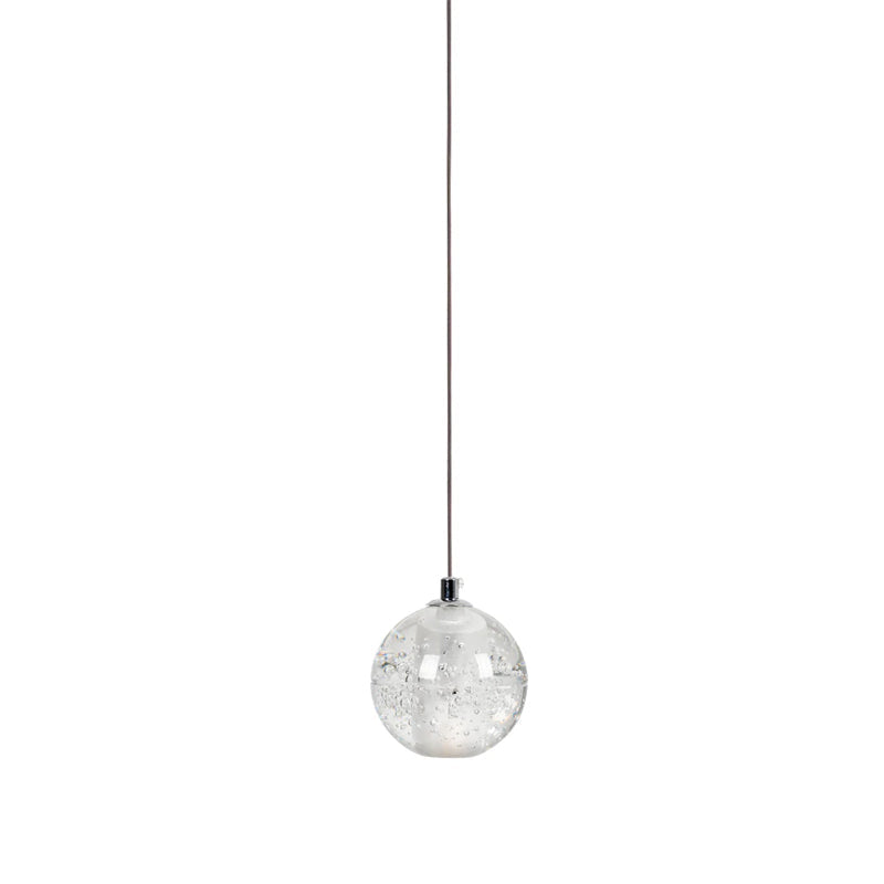 A single clear glass sphere of this Clérachic pendant light on one thin cord against a white backdrop.