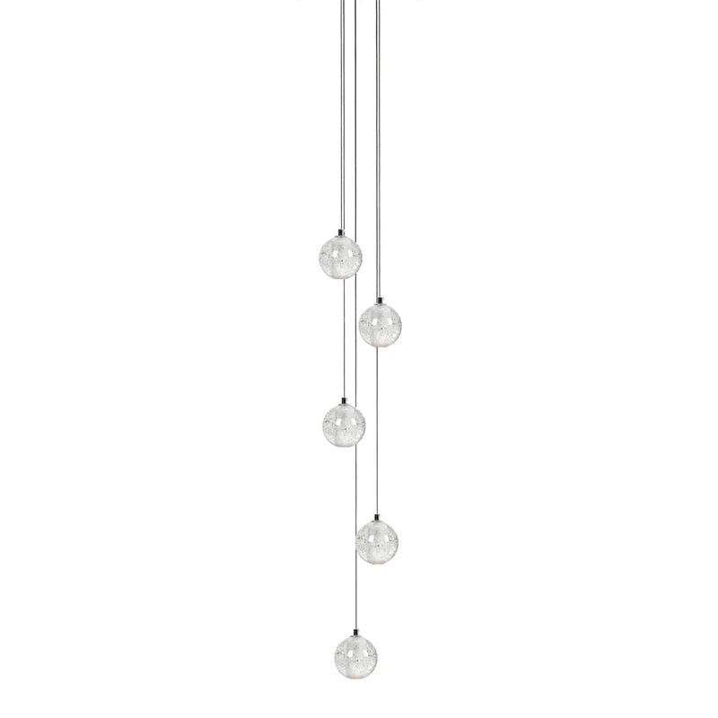 Five small clear spheres from this Clérachic pendant light hang at staggered heights on dark cords on a white backdrop.