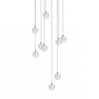 A spread of nine clear spheres from this Clérachic pendant light hangs on dark cords at varied heights on white.