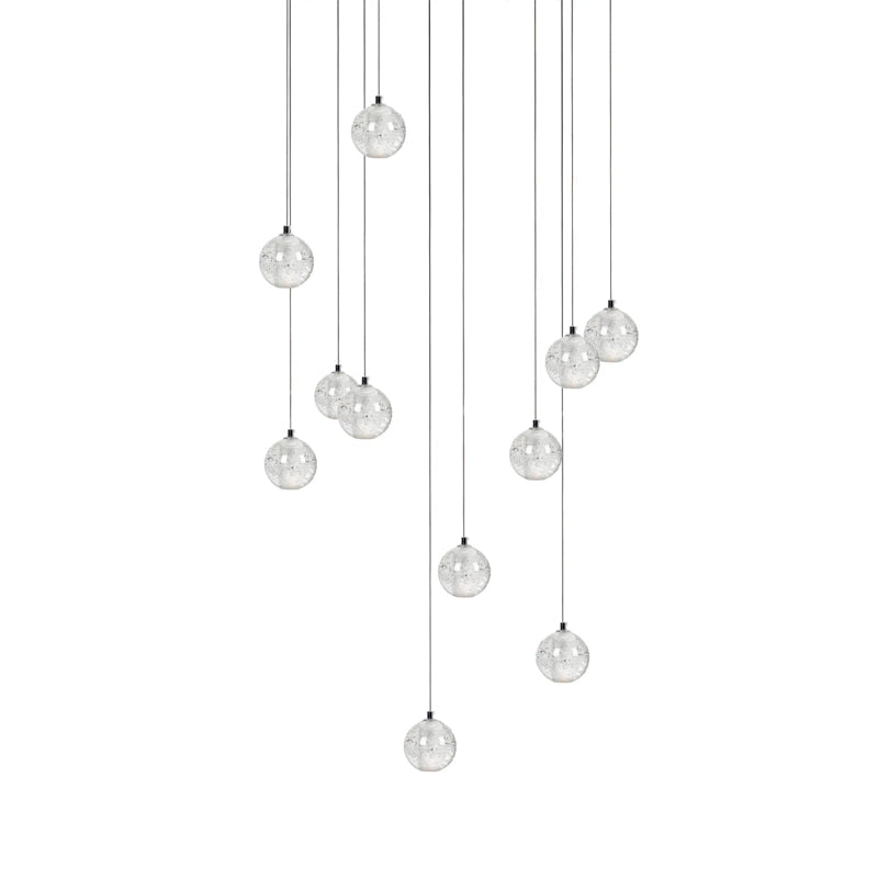 Eleven clear spheres from this Clérachic pendant light hang at uneven heights on thin cords, shown on white.