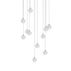 This Clérachic pendant light with a slightly different spread of clear spheres, hung on cords of mixed length on white.