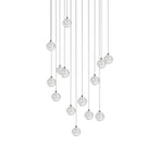 A larger group of clear spheres from this Clérachic pendant light, hung in a loose tall arrangement on white.