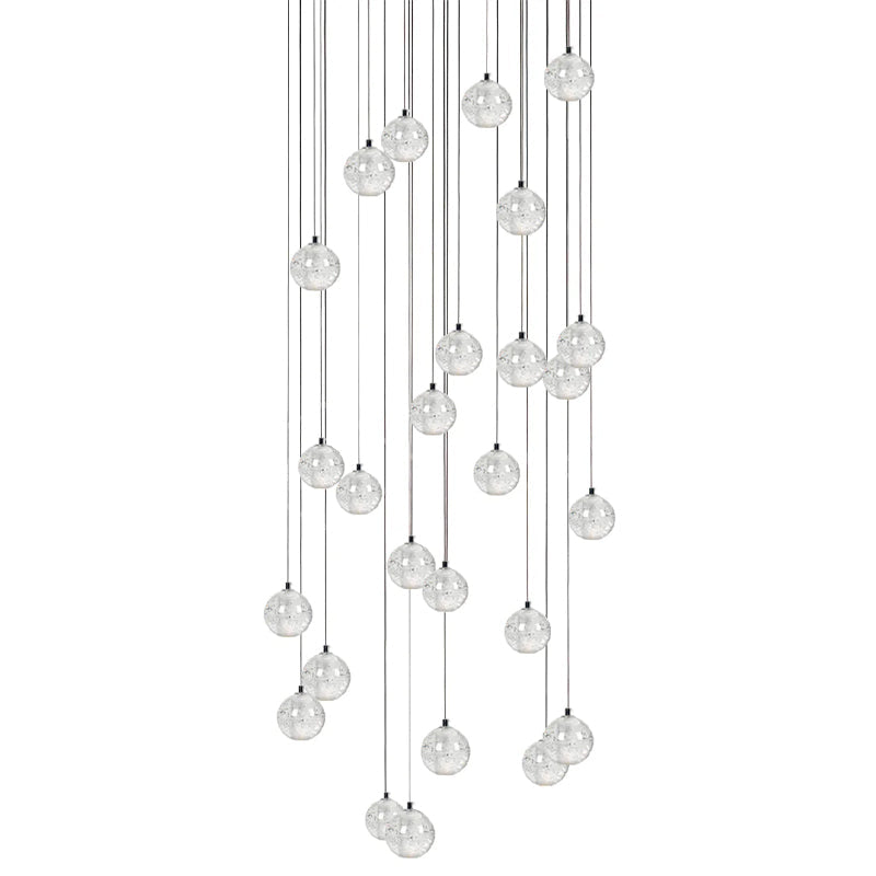 A dense hanging group of clear spheres from this Clérachic pendant light, cords of many lengths on a white backdrop.