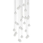 A dense hanging group of clear spheres from this Clérachic pendant light, cords of many lengths on a white backdrop.