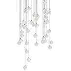 A wide, heavy cluster of clear spheres from this Clérachic pendant light, hung on cords of many lengths on white.