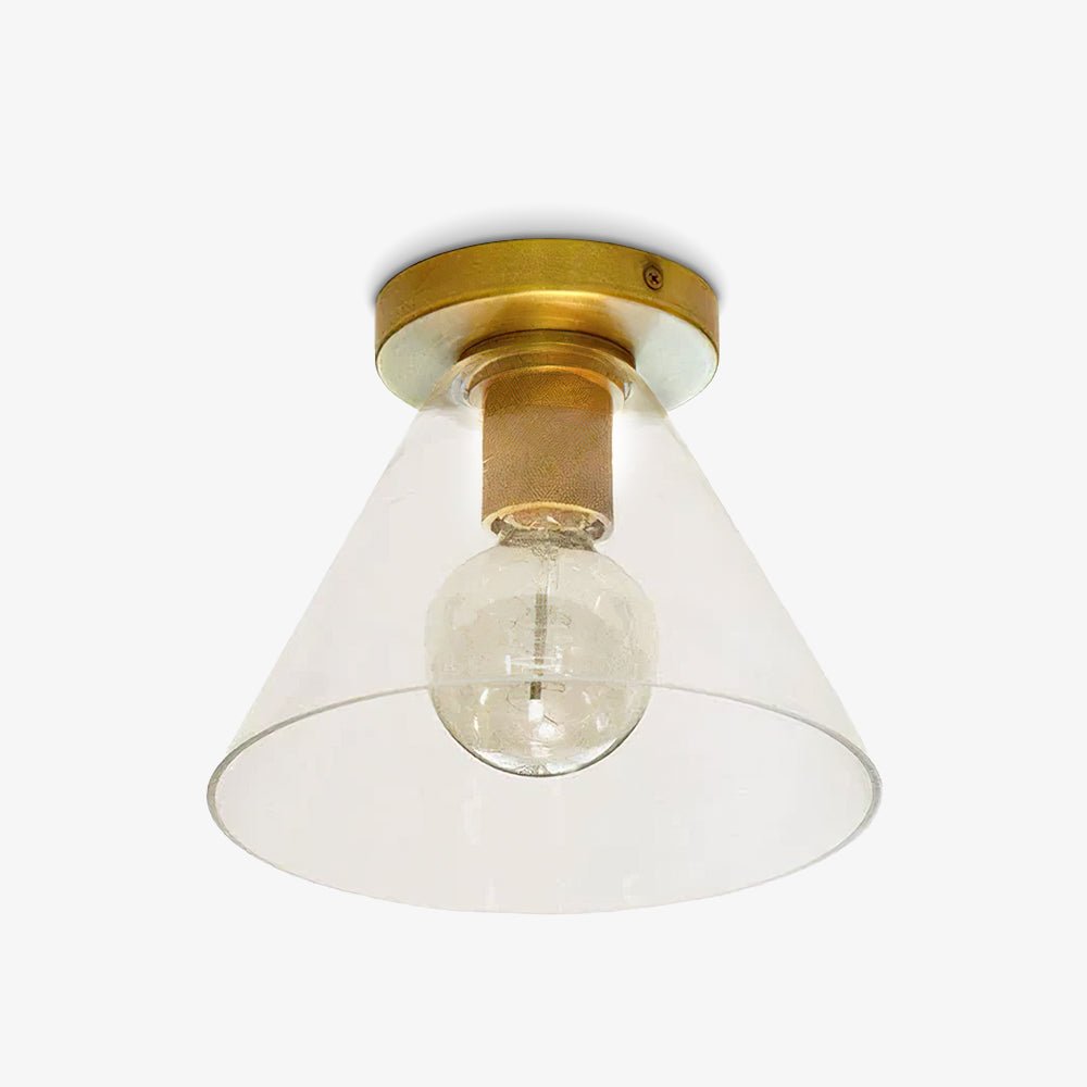 Brass flush mount with a clear conical glass shade and a round bulb inside, on a white background, from Clérachic.